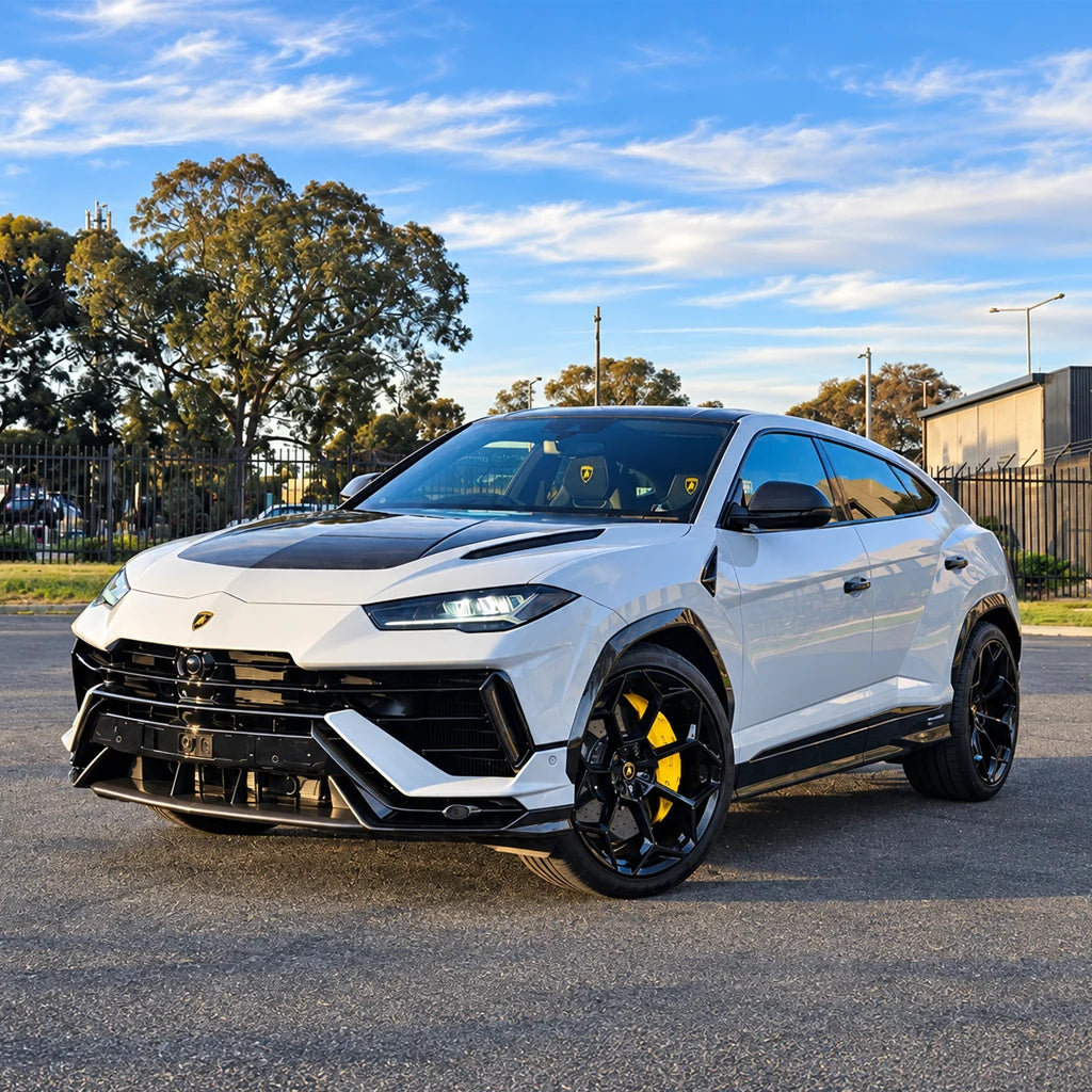 White Lamborghini Urus with black accents and yellow brake calipers, photographed outdoors
